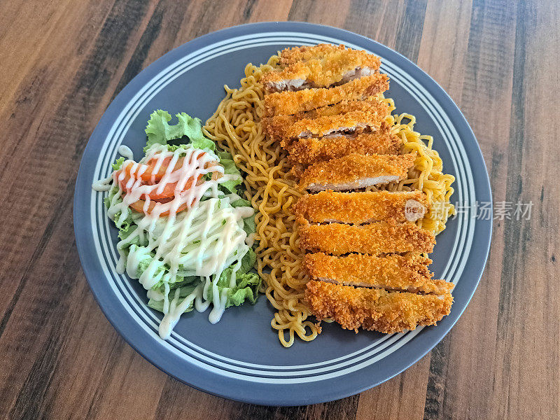 美味的鸡肉炸面加黄瓜，番茄，生菜和蛋黄酱。Mi Goreng Ayam Katsu。食品菜单。